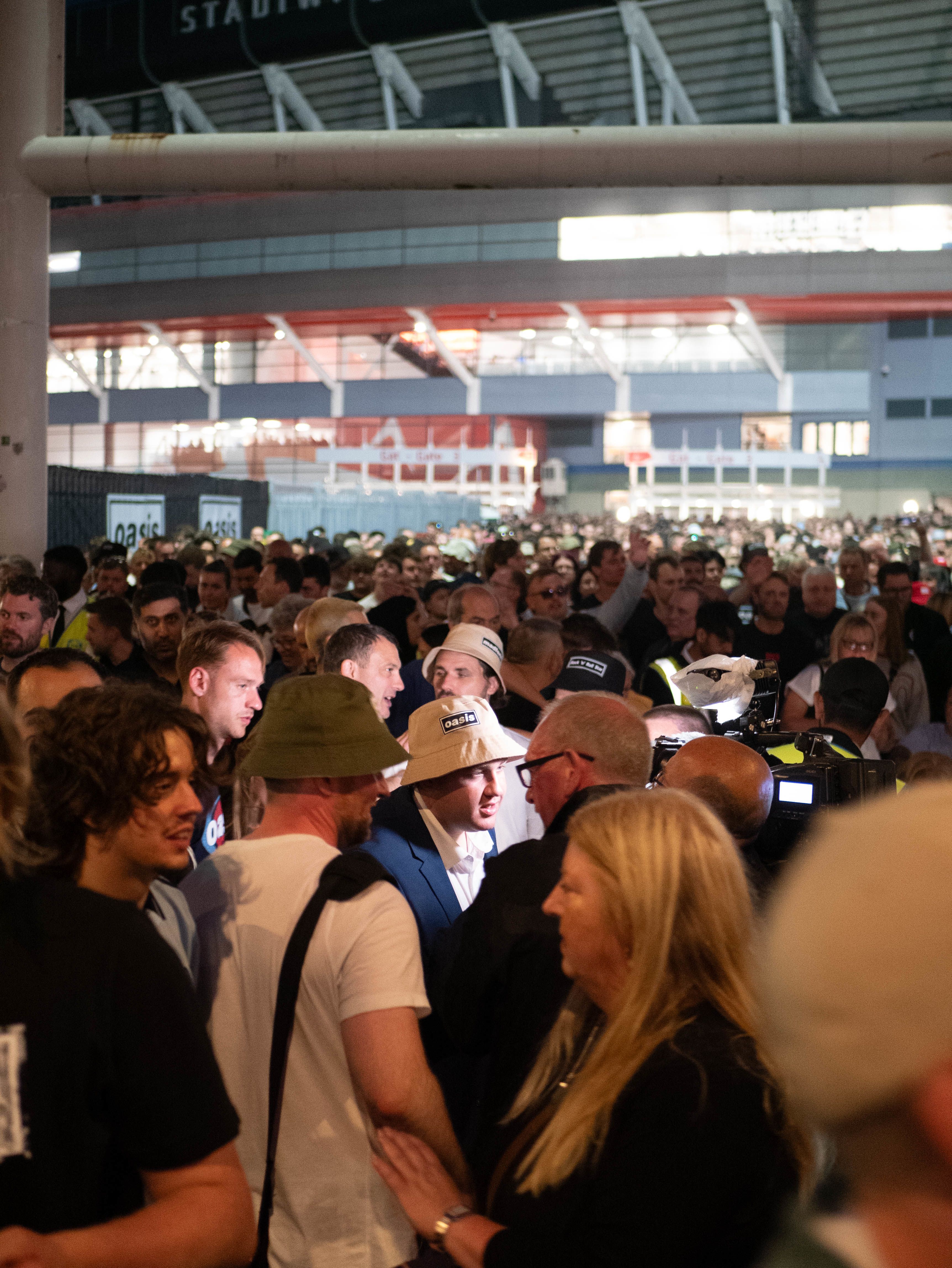 Man in bucket hat getting interviewed in a crowd outside the Principality Stadium