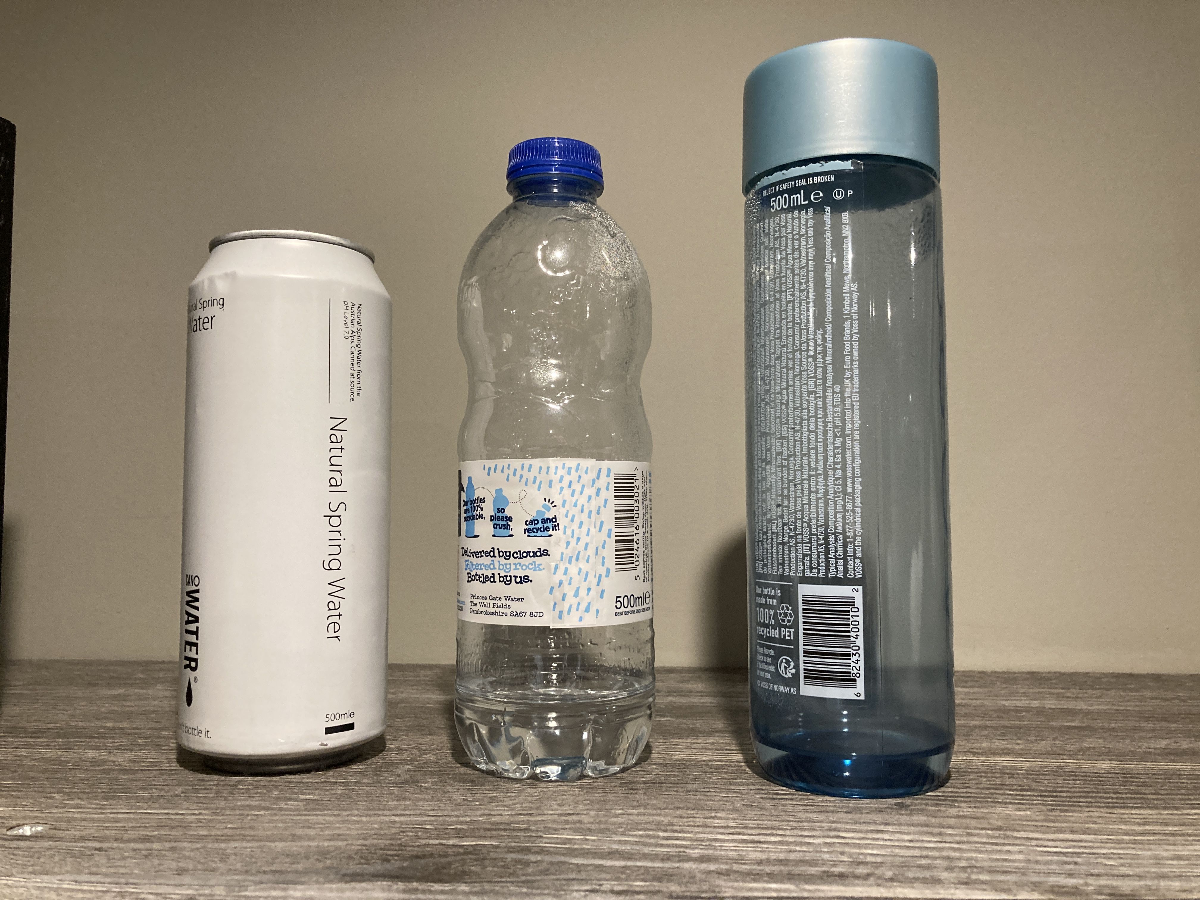 Three bottled water containers - a can, a plastic bottle, and a larger cylindrical plastic bottle