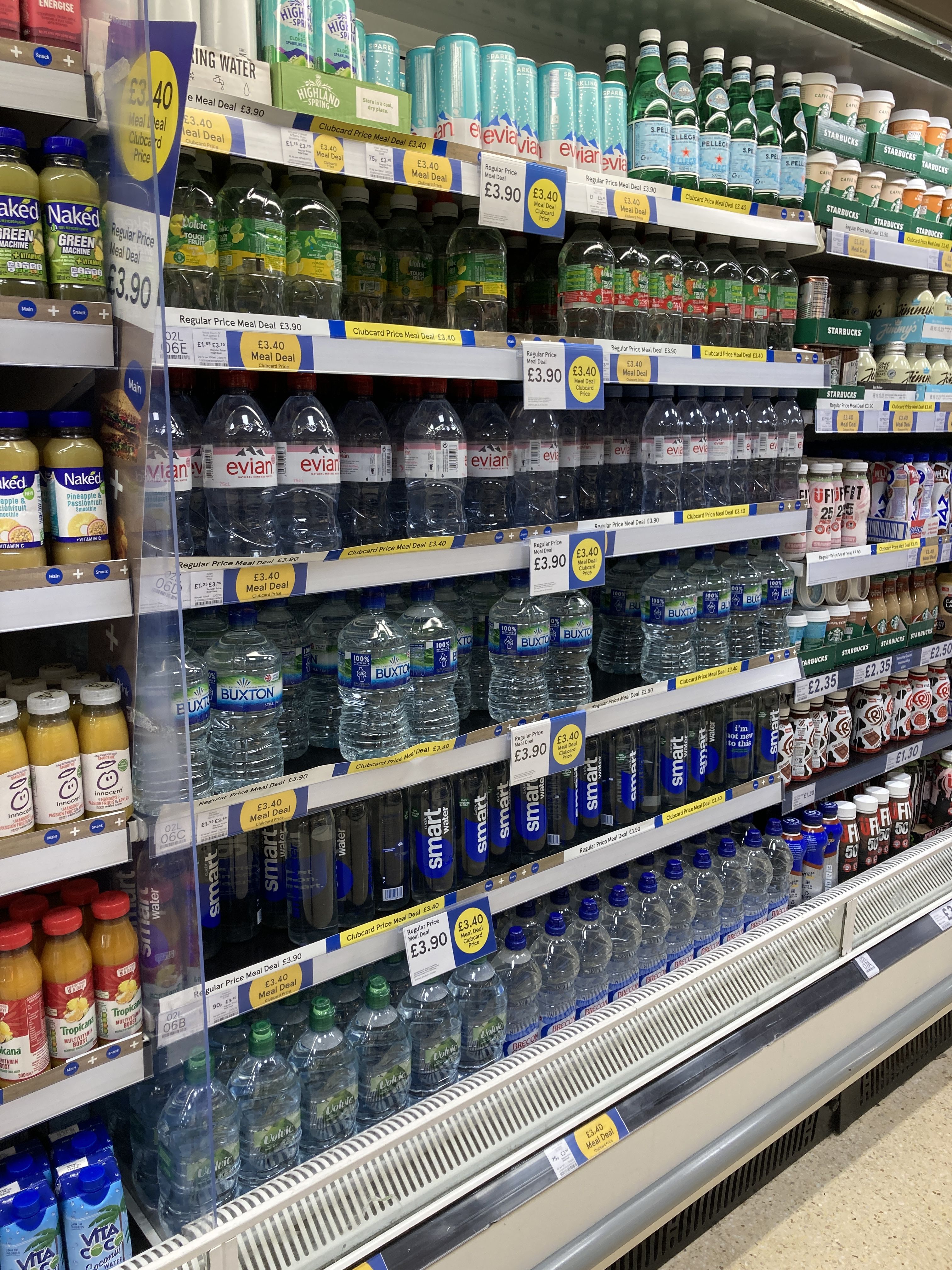 A supermarket shelf filled with different brands of bottled water